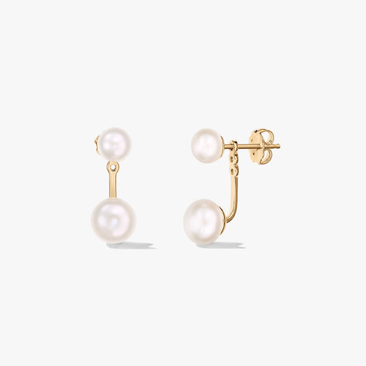 Paire de puces d’oreilles ear jacket en argent sterling plaqué or, ornées de perles blanches naturelles, présentées sur fond blanc — une vue de face et une vue de profil avec fermoir papillon.