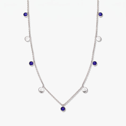 Collier à stations en argent sterling avec cabochons ronds en lapis-lazuli et pastilles en argent poli sur fond blanc.