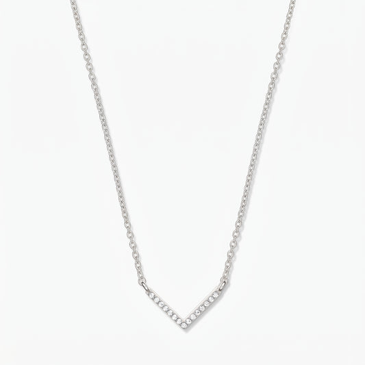 Collier en argent en forme de V avec chaîne délicate et pendentif chevron pavé d’oxydes de zirconium, sur fond blanc.