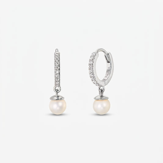 Paire de créoles en argent pavées de zirconia, agrémentées de perles naturelles blanches rondes pendantes, sur fond blanc.