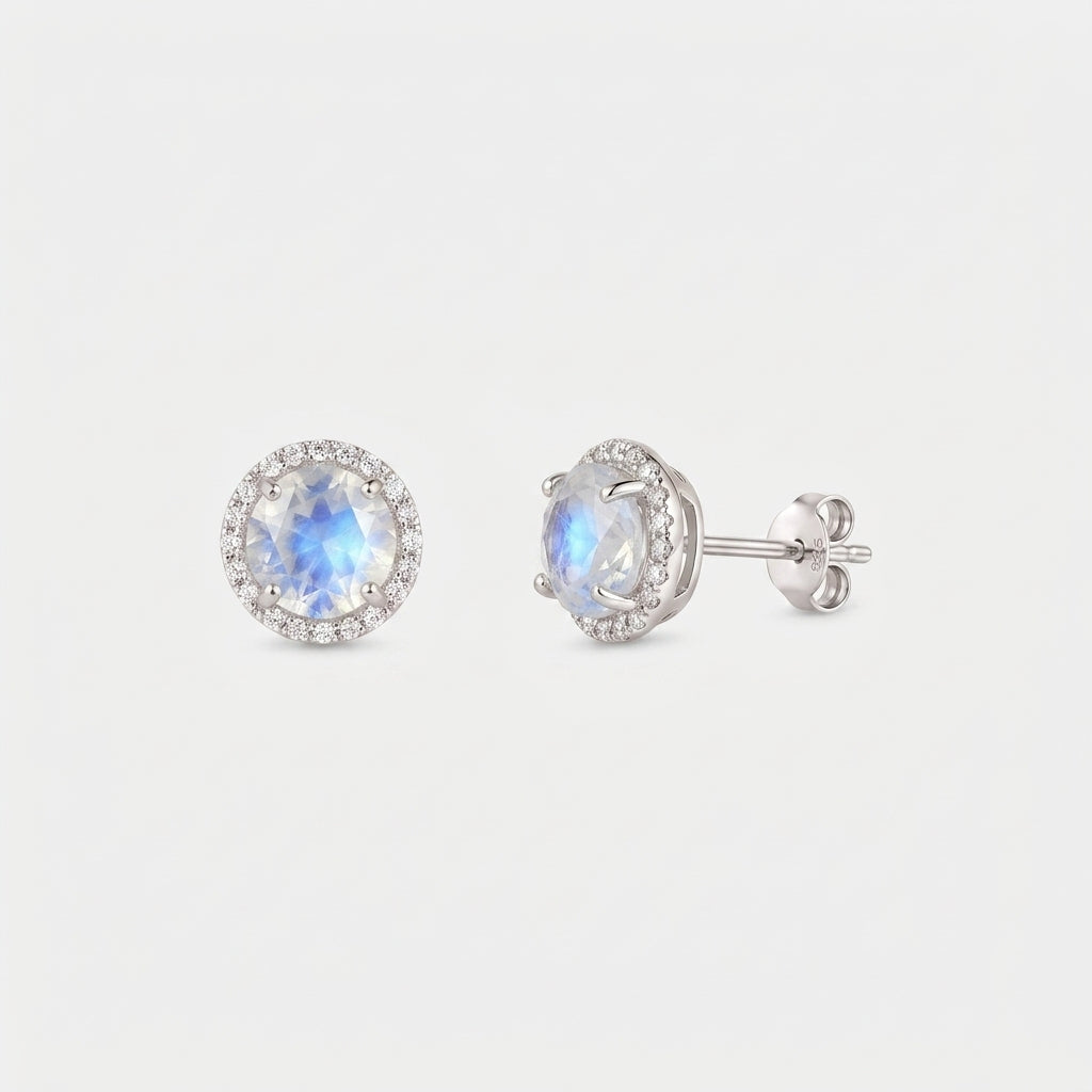 Paire de boucles d’oreilles puces halo Keira en pierre de lune en argent sterling 925, l’une vue de face et l’autre vue de profil avec attache papillon, sur fond blanc.