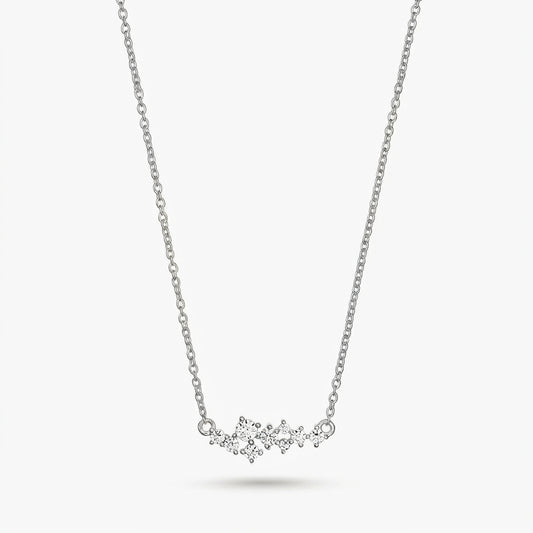 Collier constellation délicat en argent avec de petites pierres transparentes sur une fine chaîne, isolé sur fond blanc.