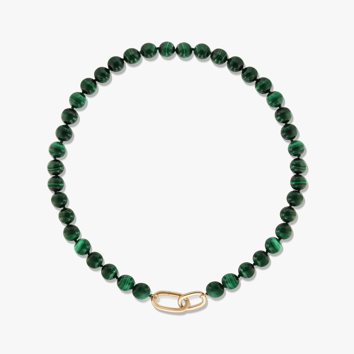 Collier en perles de malachite verte avec fermoir en argent sterling plaqué or en forme d’agrafe, sur fond blanc.