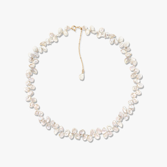 Collier Brielle en perles de culture dorées avec des perles baroques irrégulières et une rallonge de chaîne dorée sur fond blanc.