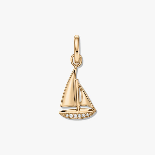 Pendentif voilier en argent sterling finition dorée avec zircones pavées le long de la coque, isolé sur fond blanc.