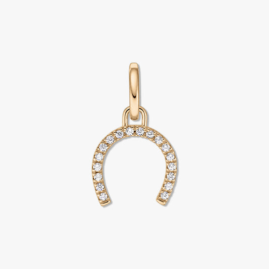 Pendentif en argent en forme de fer à cheval doré avec des pierres de zircone claire pavées sur fond blanc.
