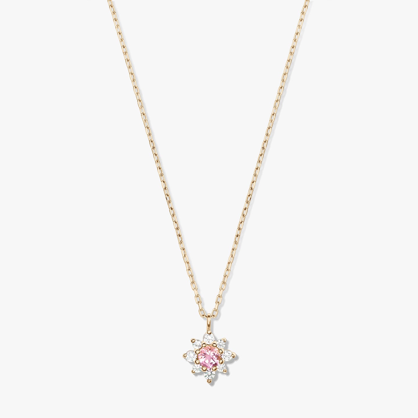 Collier en or jaune 14K avec chaîne délicate et pendentif floral, doté d’une morganite rose centrale entourée de saphirs blancs, sur fond blanc.