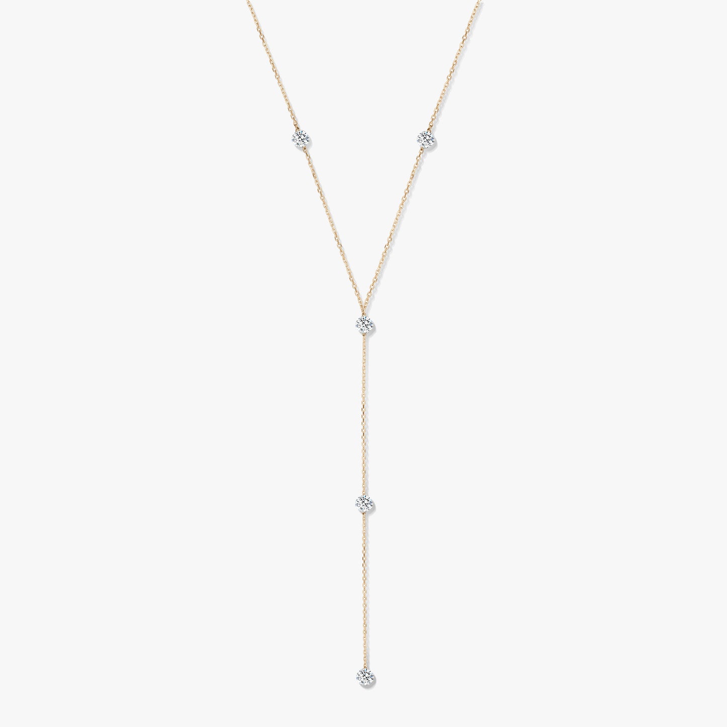 Collier lariat en or jaune 14K avec cinq diamants ronds sertis clos, sur fond blanc.