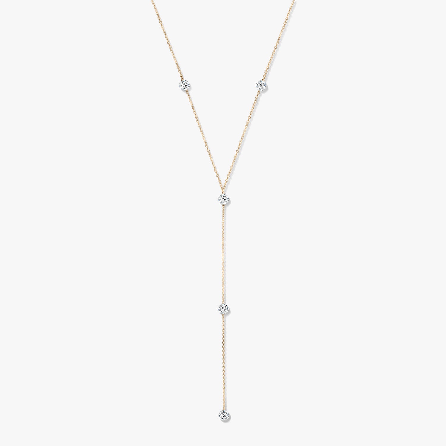 Collier lariat en or jaune 14K avec cinq diamants ronds sertis clos, sur fond blanc.