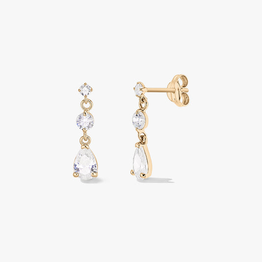 Paire de boucles d’oreilles goutte de pluie en or jaune 14K avec trois oxydes de zirconium blancs (tailles ronde et poire), présentées de face et de profil sur fond blanc.