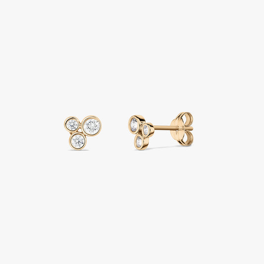Paire de puces d’oreilles en or jaune 14K style bulle, ornées de trois zircones blanches rondes montées en serti clos, présentées de face et de profil sur fond blanc.