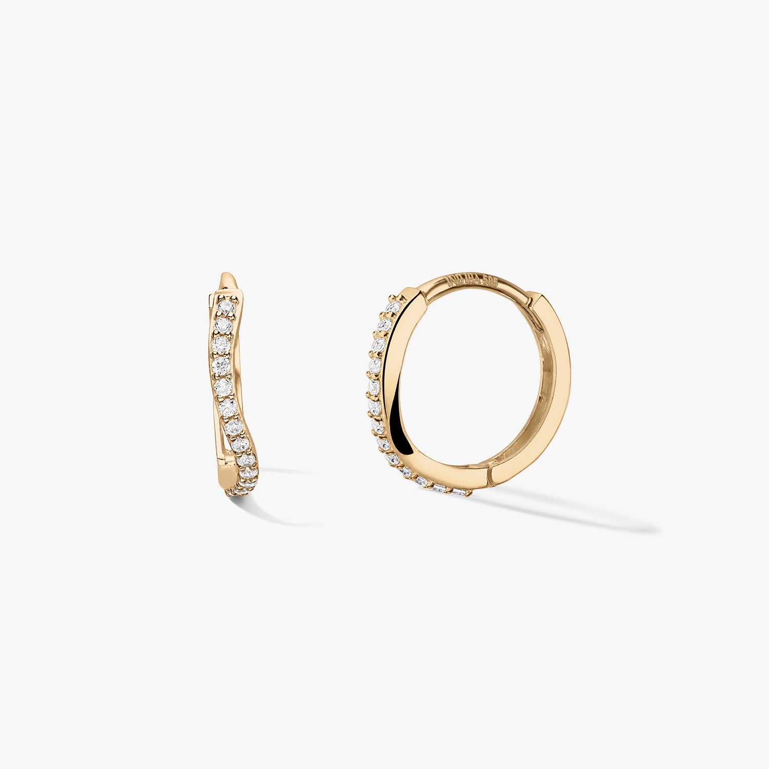 Paire de créoles huggie en or jaune 14k avec une rangée pavée ondulée de zirconias blancs, sur fond blanc épuré — une vue de profil et une créole ouverte montrant la fermeture.