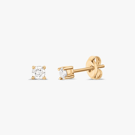 Paire de boucles d'oreilles en or avec diamant solitaire, présentées sur fond blanc.