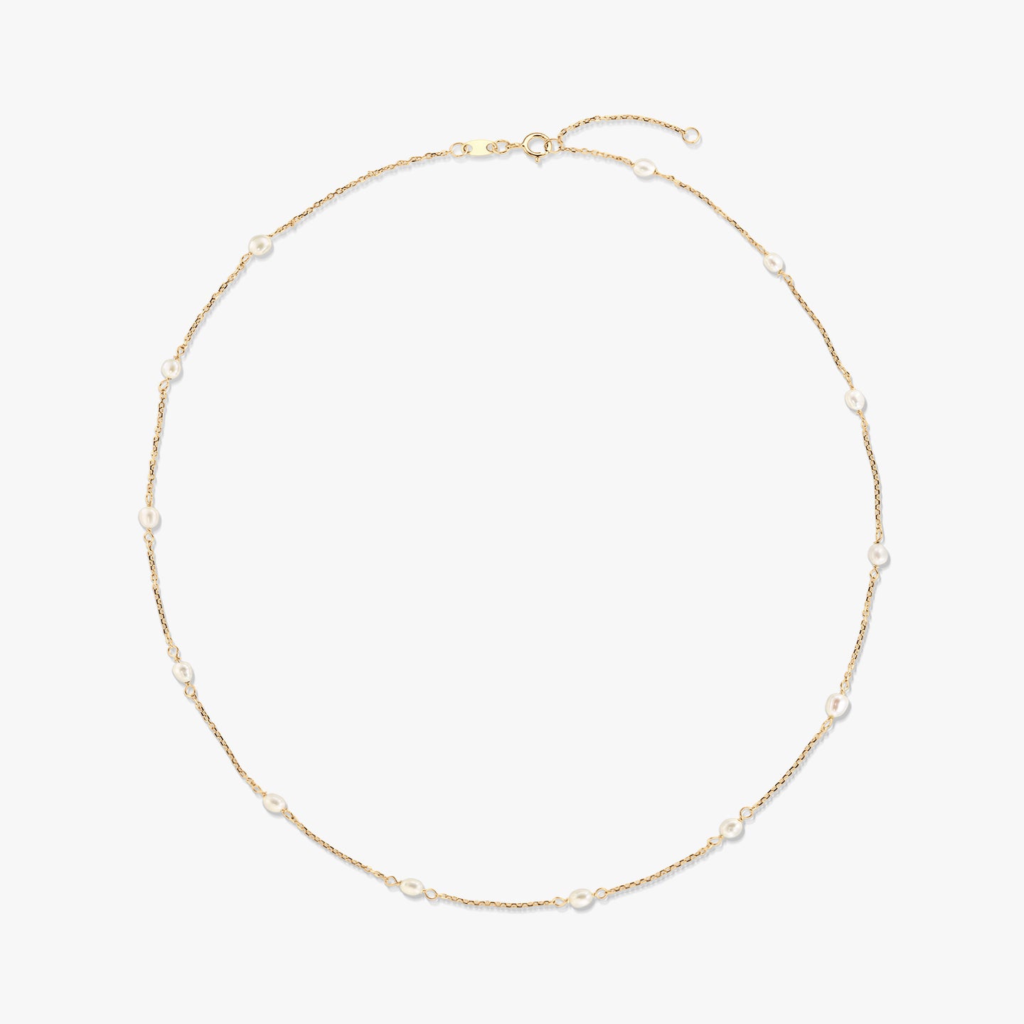Collier station en or jaune 14K avec de petites perles blanches naturelles espacées le long d’une fine chaîne, isolé sur fond blanc.
