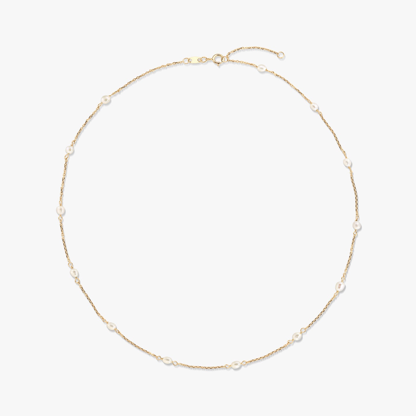 Collier station en or jaune 14K avec de petites perles blanches naturelles espacées le long d’une fine chaîne, isolé sur fond blanc.