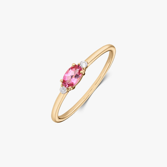 Bague en or jaune 14 K avec une tourmaline rose ovale au centre, encadrée de deux petits diamants ronds sur une monture fine, isolée sur fond blanc.