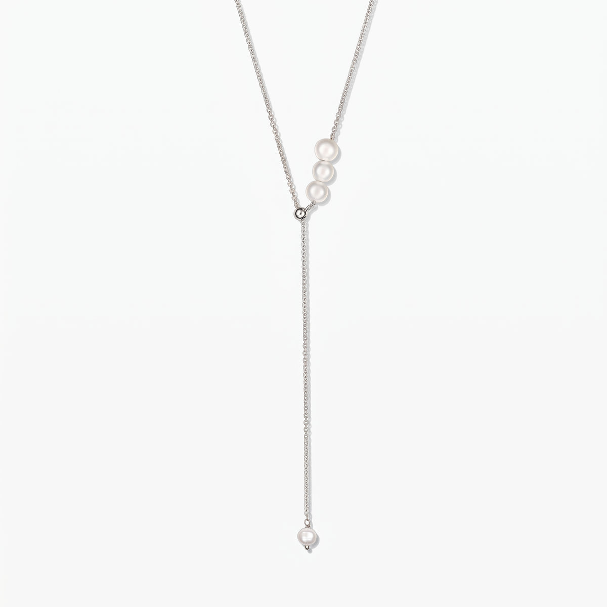 Élégant collier lariat en argent sterling réglable orné de perles de culture blanches, centré sur fond blanc.