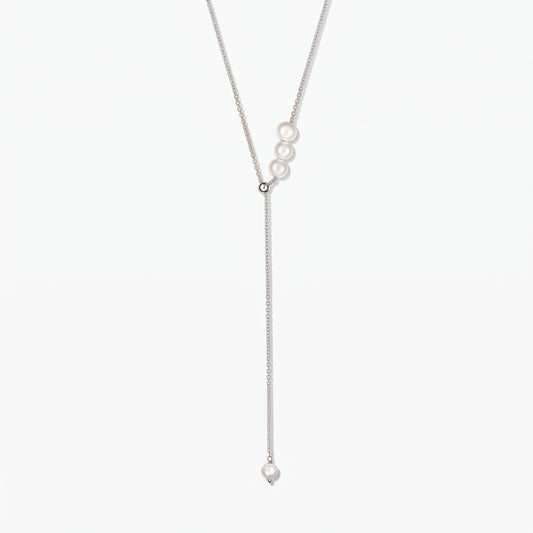 Élégant collier lariat en argent sterling réglable orné de perles de culture blanches, centré sur fond blanc.