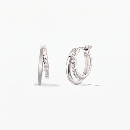 Paire de créoles doubles Siamese en argent, ornées d'un pavage d'oxydes de zirconium, sur fond blanc.