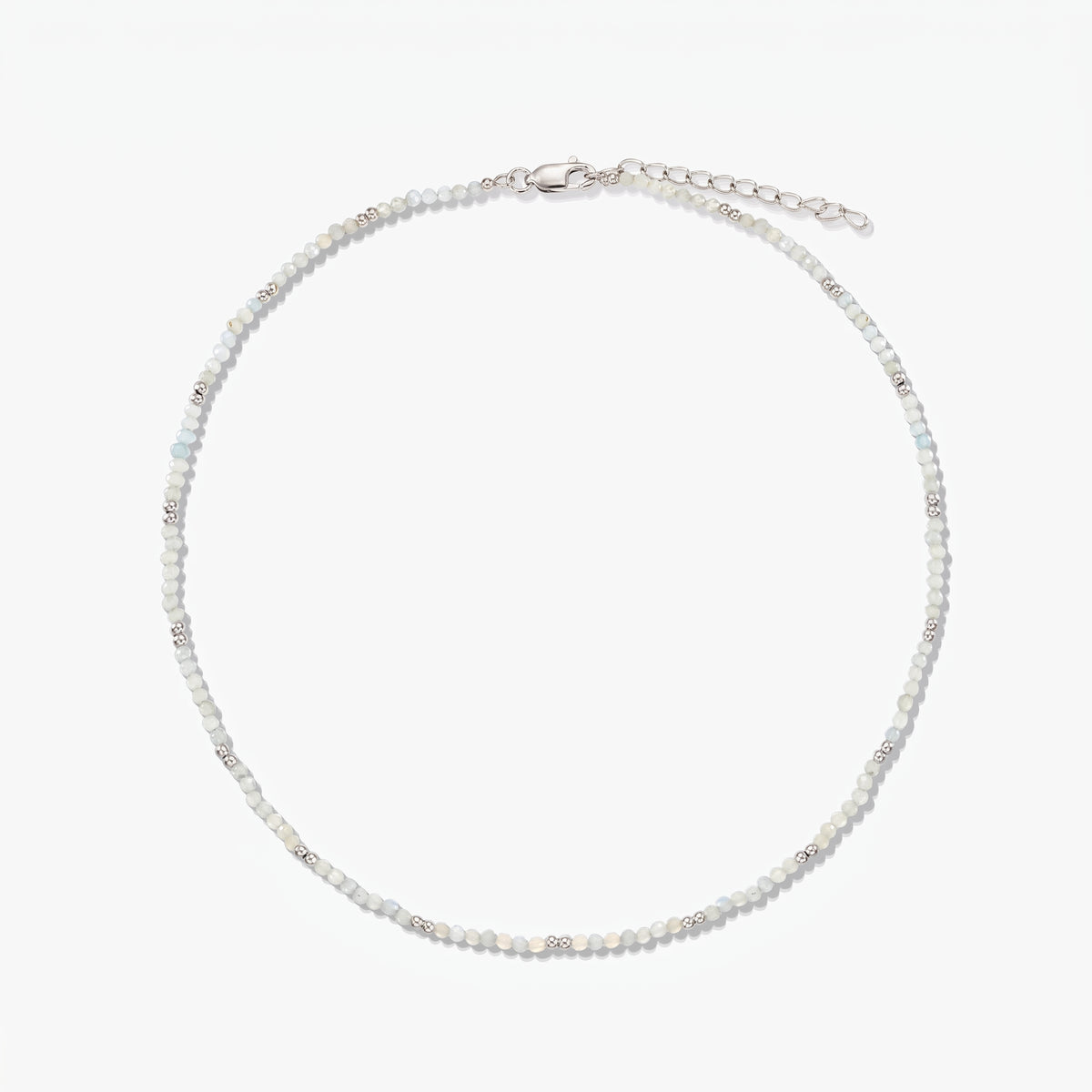 Collier délicat en argent sterling avec de petites perles de pierre de lune et une chaîne de rallonge réglable, photographié sur fond blanc.