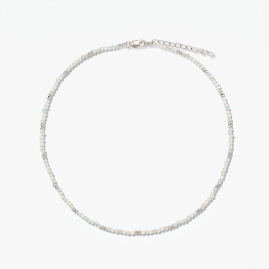 Collier délicat en argent sterling avec de petites perles de pierre de lune et une chaîne de rallonge réglable, photographié sur fond blanc.