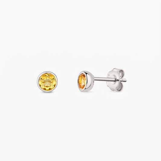 Clous d’oreilles en argent avec pierres de naissance en citrine rondes sur fond blanc, présentés de face et de profil avec fermoirs papillon.