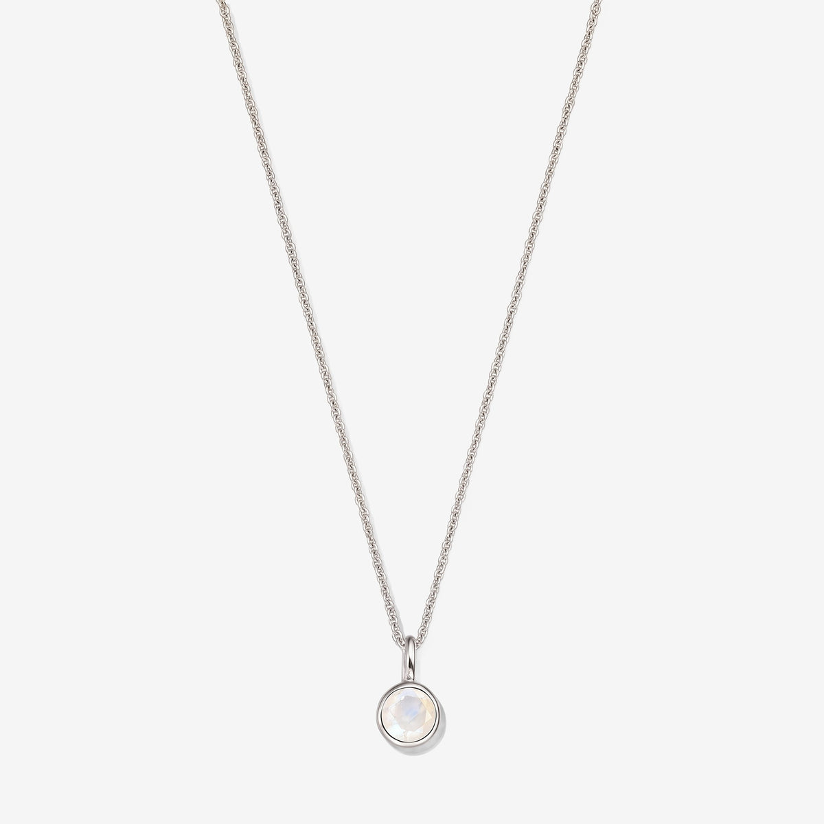 Collier en argent sterling avec un pendentif en pierre de lune ronde sertie en bezel sur une fine chaîne, photographié sur un fond blanc.