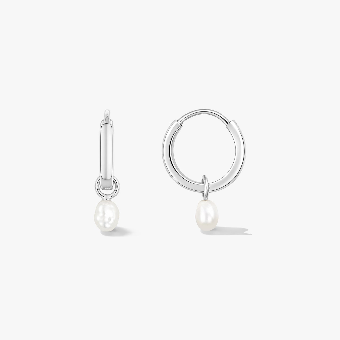 Paire de créoles en argent sterling avec de petites perles naturelles pendantes sur fond blanc, l’une vue de face et l’autre de côté.