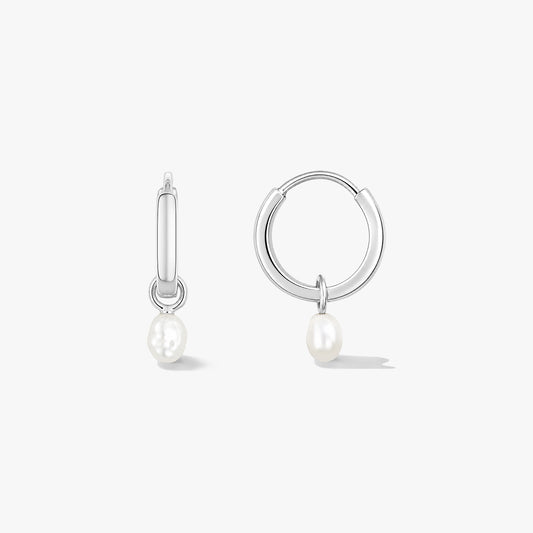 Paire de créoles en argent sterling avec de petites perles naturelles pendantes sur fond blanc, l’une vue de face et l’autre de côté.