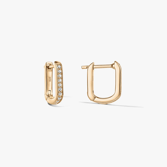 Paire de boucles d'oreilles créoles huggy en forme de U de couleur or en argent 925 avec zirconias clairs pavés, présentées sur un fond blanc avec une boucle ouverte et l'autre fermée.