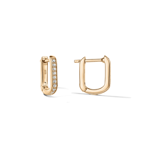 Paire de boucles d'oreilles huggie en forme de U en argent 925 avec finition dorée ; un anneau pavé de zirconias clairs, présenté de face et de côté sur un fond transparent et épuré.