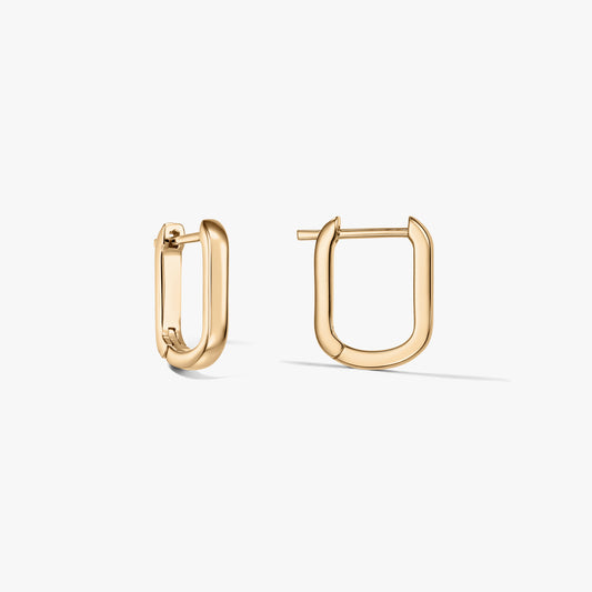 Paire de boucles d’oreilles créoles en argent sterling plaqué or, en forme de U, sur fond blanc, l’une ouverte, l’autre fermée.