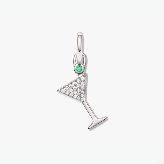 Pendentif en forme de verre à cocktail en argent avec pavé de zirconia blanc et petite pierre verte en accent sur fond blanc épuré.