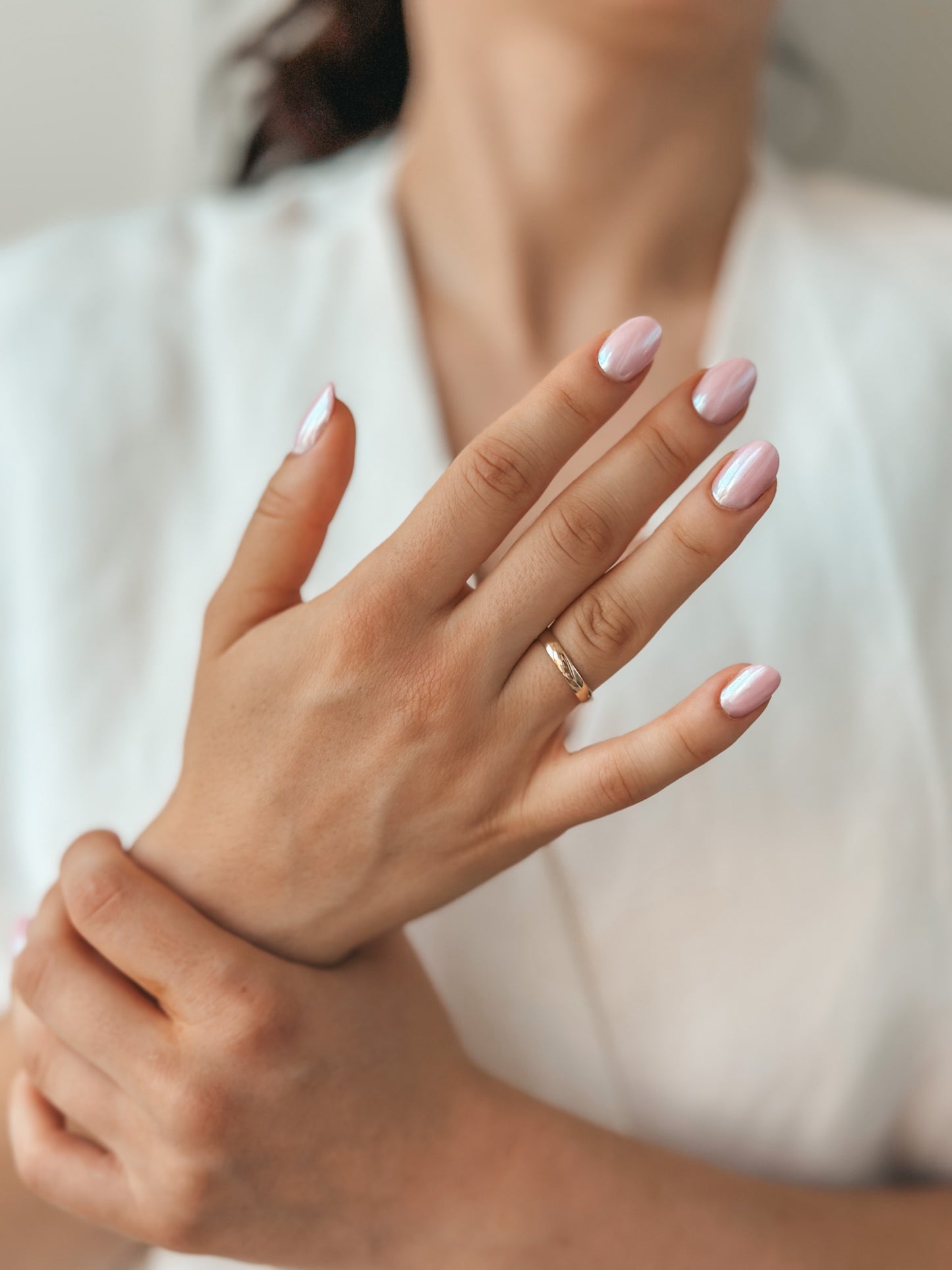 Gros plan sur des mains avec une alliance en or et des ongles polis