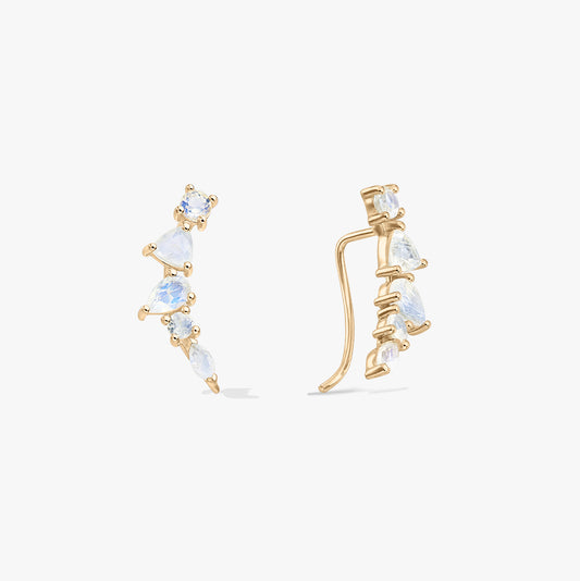Paire de boucles d’oreilles grimpantes type manchette en argent 925 ton or avec pierres de lune, sur fond blanc, vues de face et de côté, pierres à tailles mixtes.