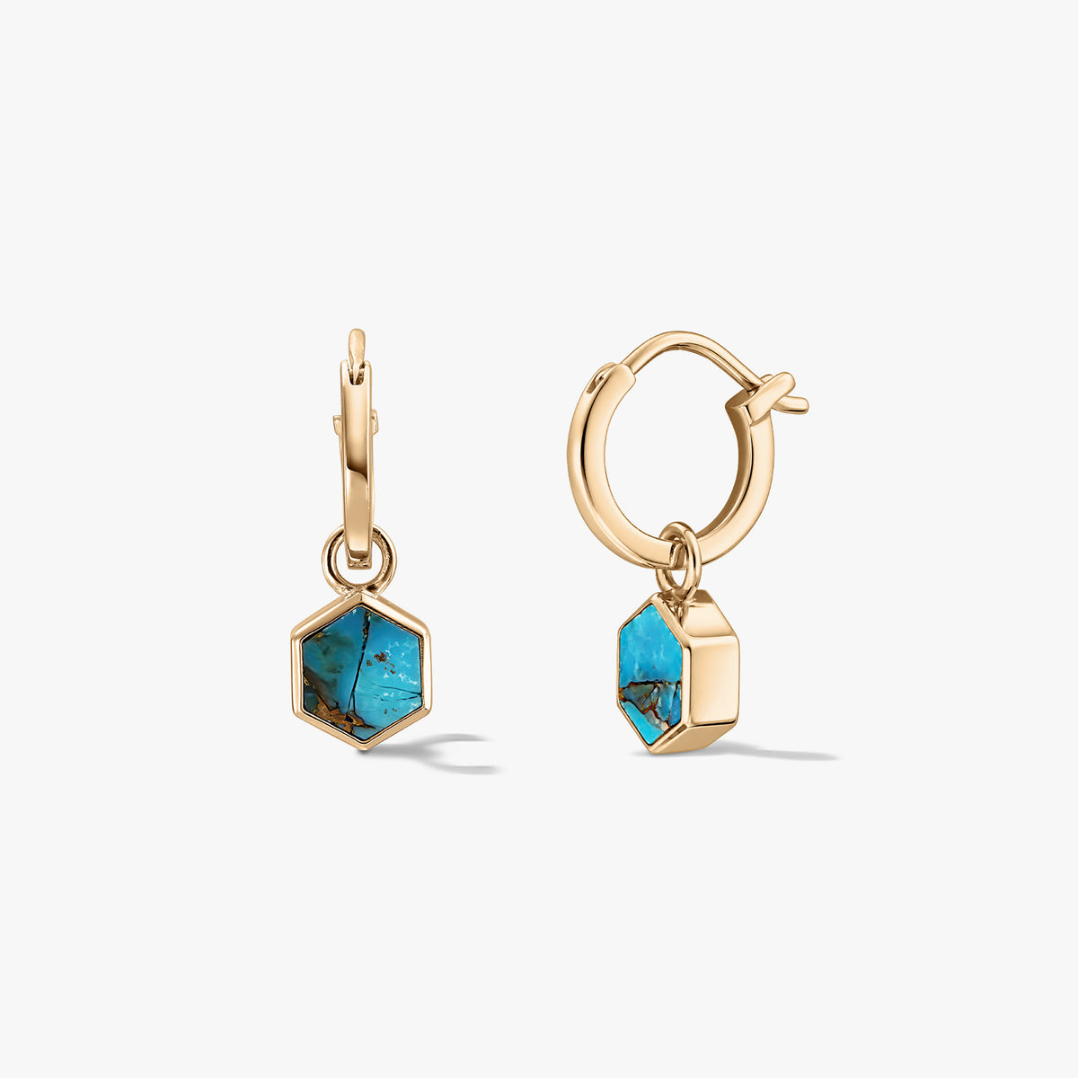 Paire de petites boucles d’oreilles créoles ton or avec breloques hexagonales en pierre turquoise bleu-cuivre sur fond blanc.