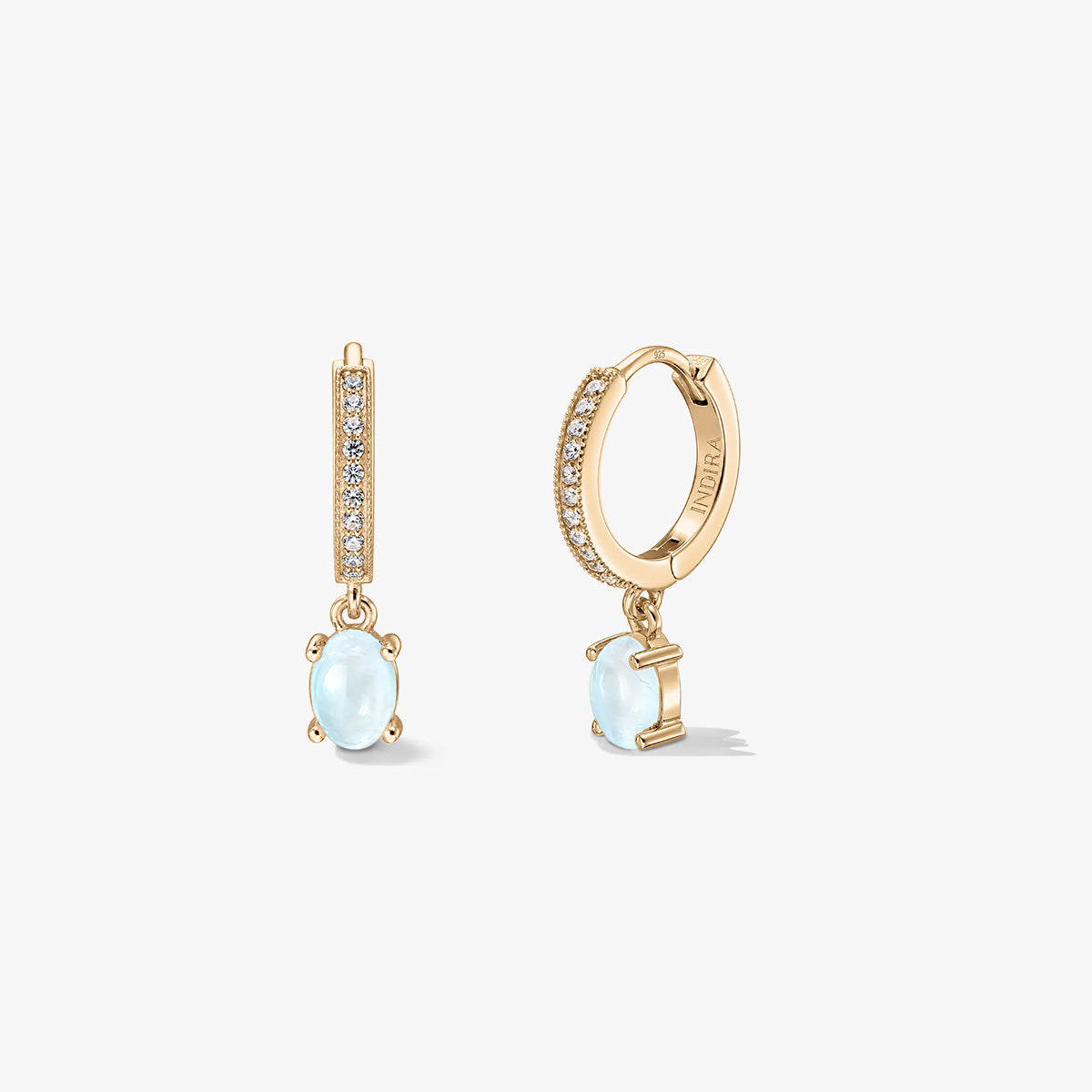 Boucles d'oreilles argentées Indira Golden Gem Huggies avec pendentifs en pierre de lune ovale et créoles serties de pavé, présentées sur fond blanc vues de face et de côté.
