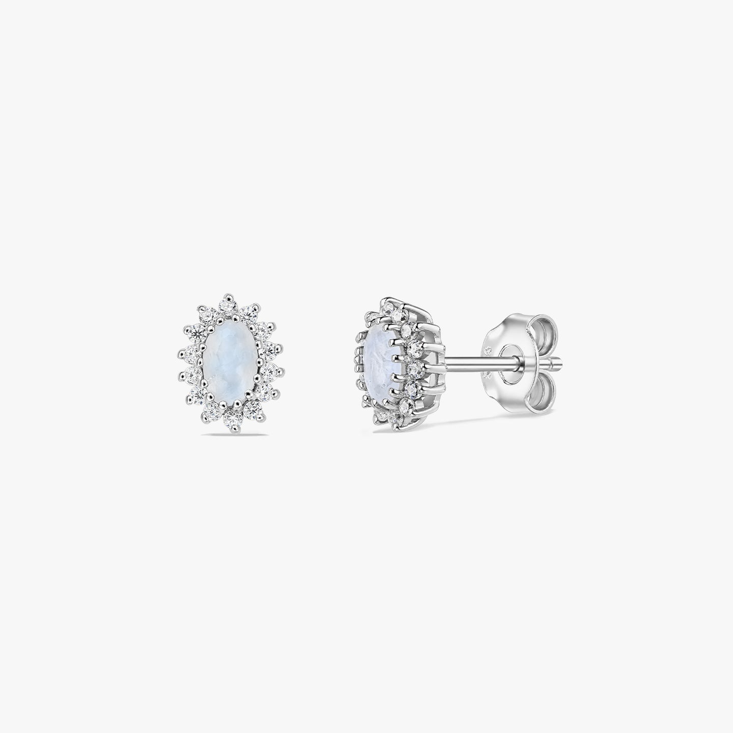 Paire de boucles d’oreilles puces en argent sterling avec halo en pierre de lune sur fond blanc, présentées de face et de profil, avec centres cabochon ovales et attaches papillon.