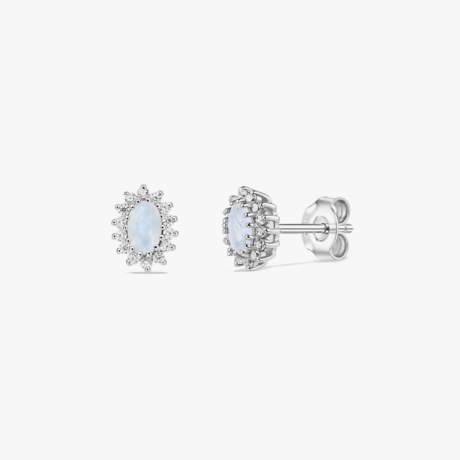 Paire de boucles d’oreilles puces en argent sterling avec halo en pierre de lune sur fond blanc, présentées de face et de profil, avec centres cabochon ovales et attaches papillon.