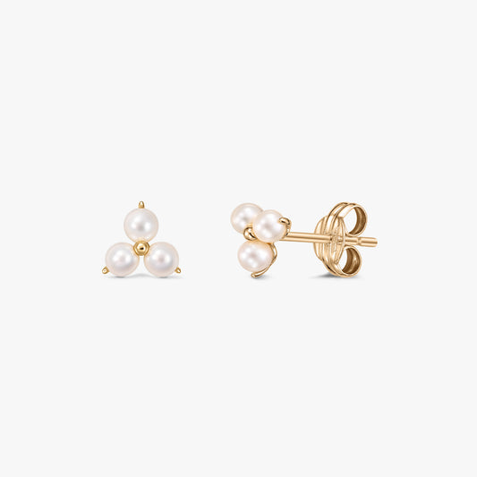 Paire de boucles d'oreilles clous Pointe en or avec trois perles de culture blanches regroupées en triangle sur fond blanc, vues de face et de côté avec papillons.