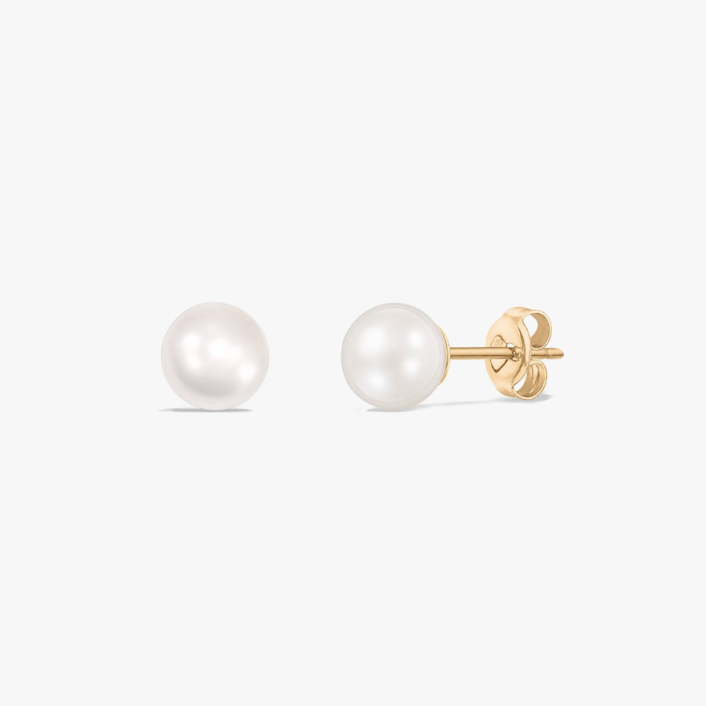 Paire de boucles d’oreilles puces en perle en or jaune 14 carats avec fermoirs poussette sur fond blanc.