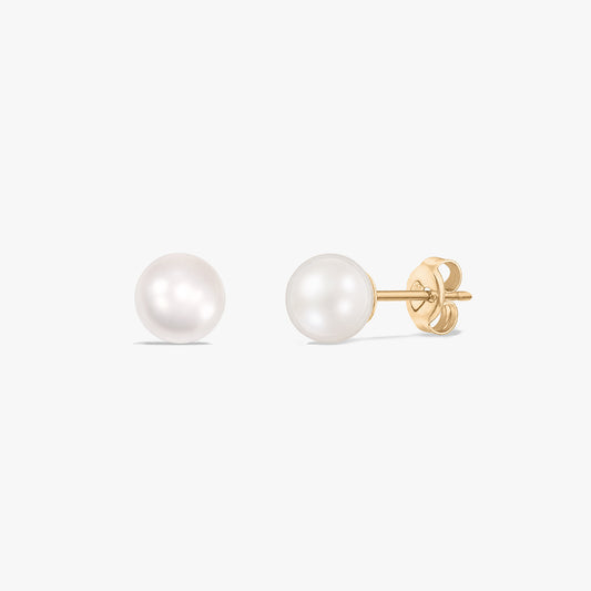 Paire de boucles d’oreilles puces en perle en or jaune 14 carats avec fermoirs poussette sur fond blanc.