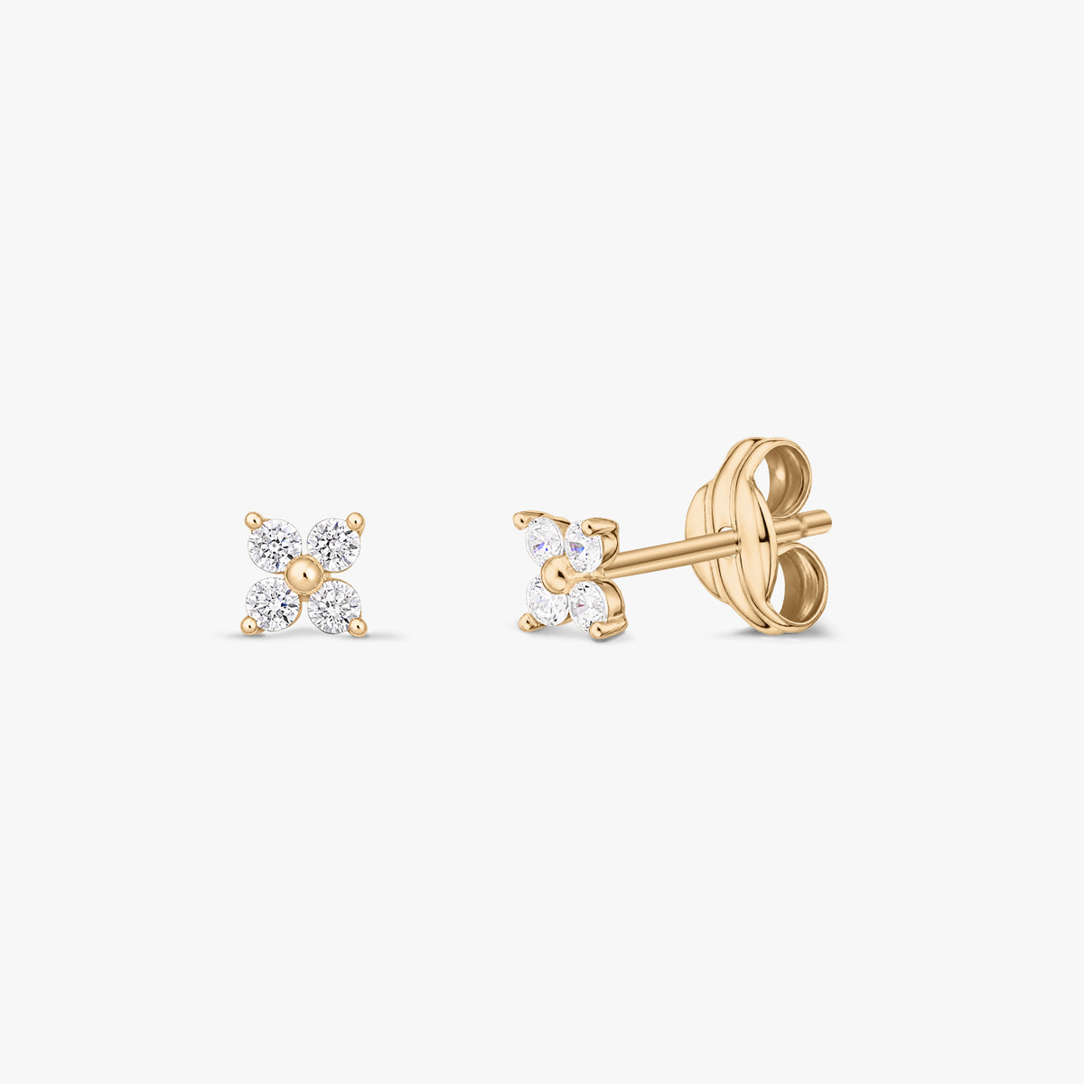Paire de puces d’oreilles en or jaune 14K avec quatre oxydes de zirconium transparents formant une petite fleur, présentées de face et de profil sur fond blanc.