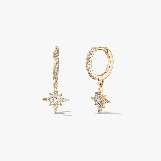Paire de mini-créoles en argent plaqué or avec pendentifs étoile rayonnante pavés de zirconias, sur fond blanc.