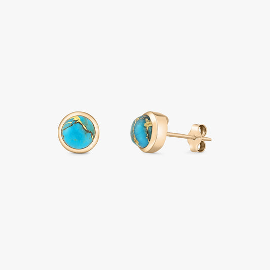 Paire de puces d'oreilles à cabochons ronds en turquoise, en argent 925 plaqué or, avec sertis clos et attaches papillon, sur fond blanc.