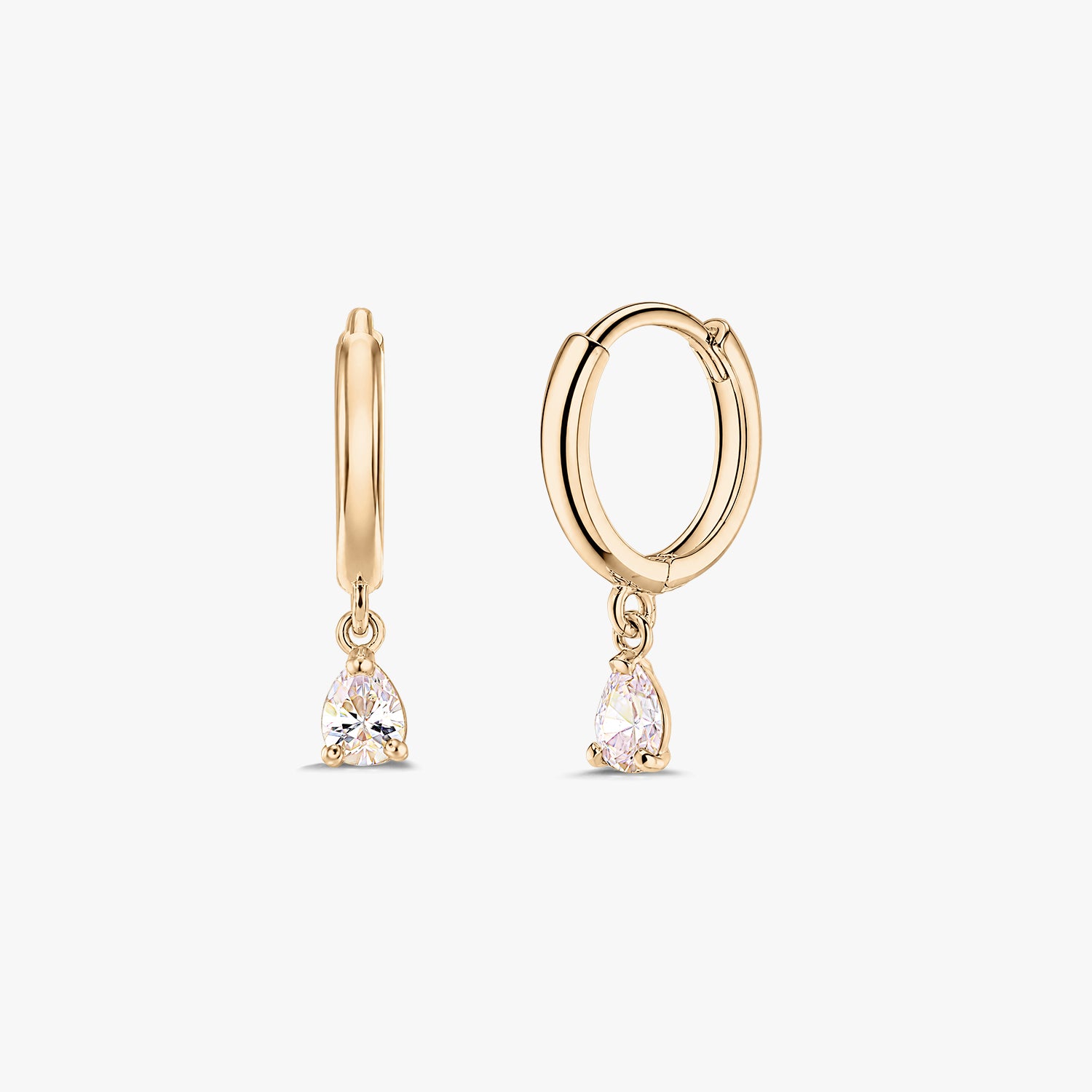 Paire de boucles d’oreilles créoles huggie en or jaune 14K avec pampilles en zircone blanche taille poire, sur fond blanc.