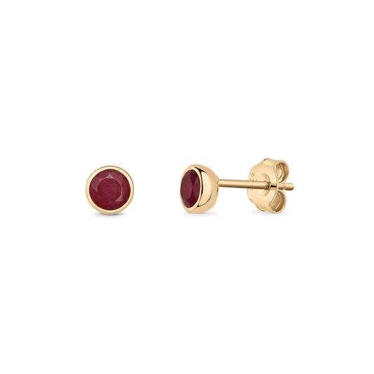 Paire de boucles d'oreilles clous en argent avec pierres de naissance rubis rondes serties dans un chaton doré et fermoir papillon, isolées sur fond transparent.