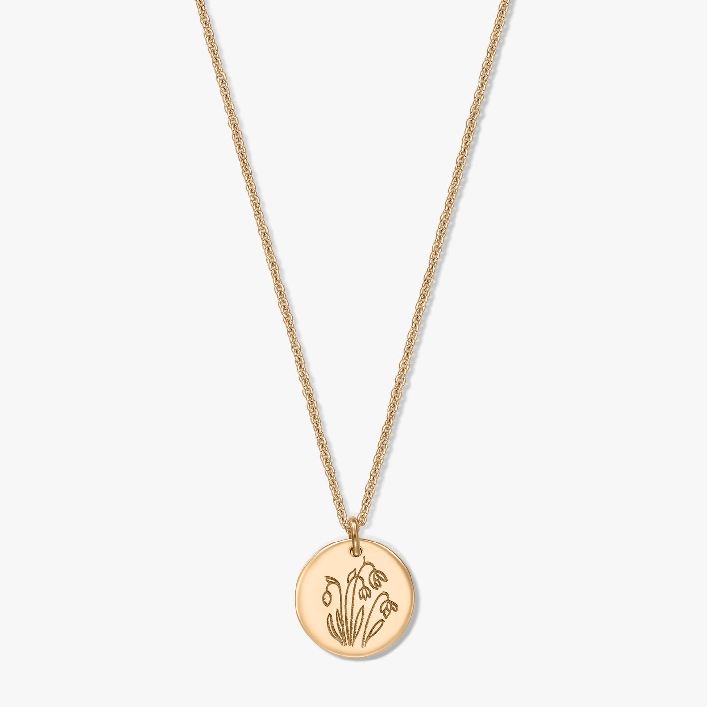 Collier en argent sterling plaqué or avec un pendentif disque rond gravé du perce-neige, fleur de naissance de janvier, présenté sur fond blanc.
