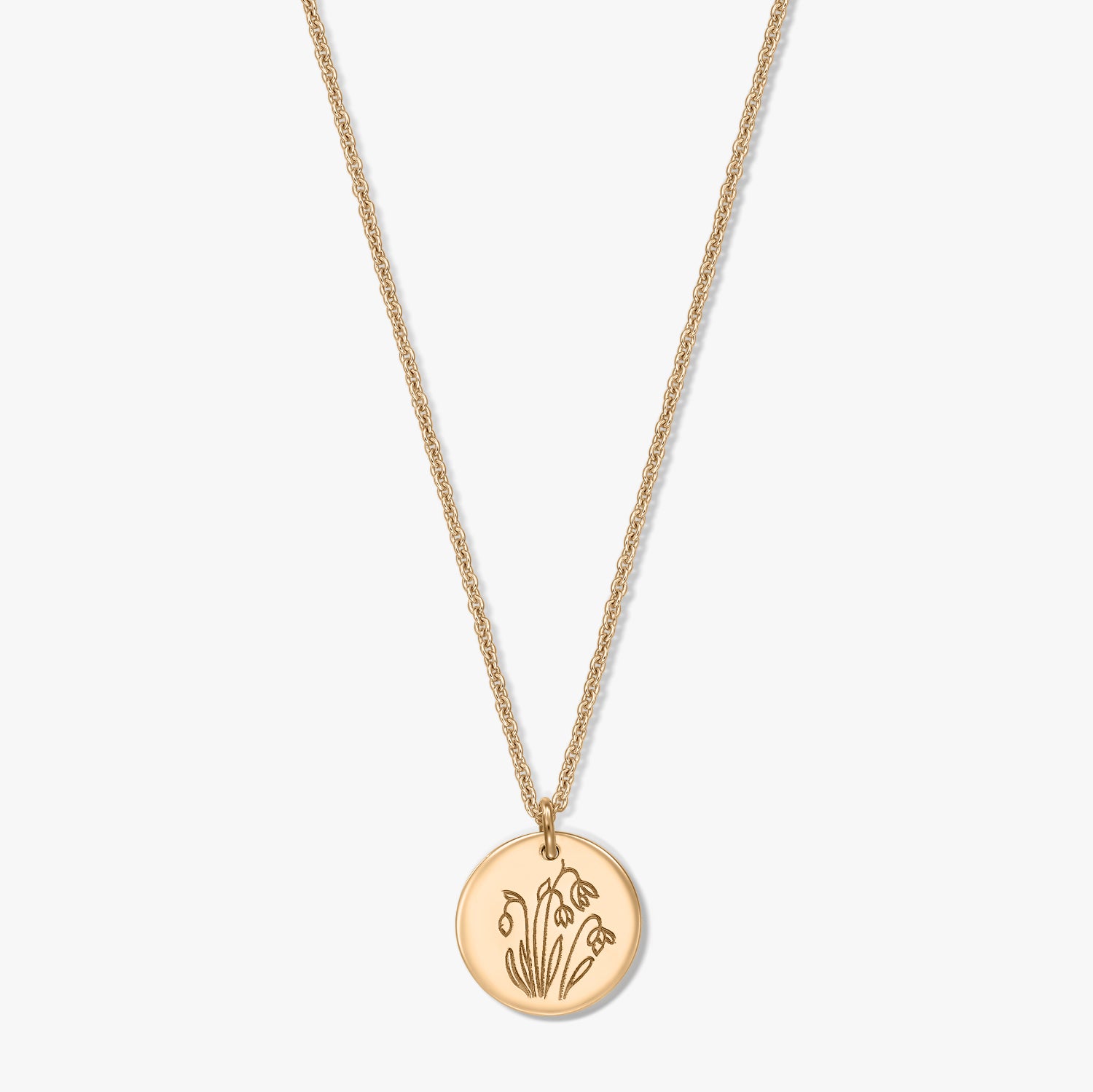 Collier en argent sterling plaqué or avec un pendentif disque rond gravé du perce-neige, fleur de naissance de janvier, présenté sur fond blanc.