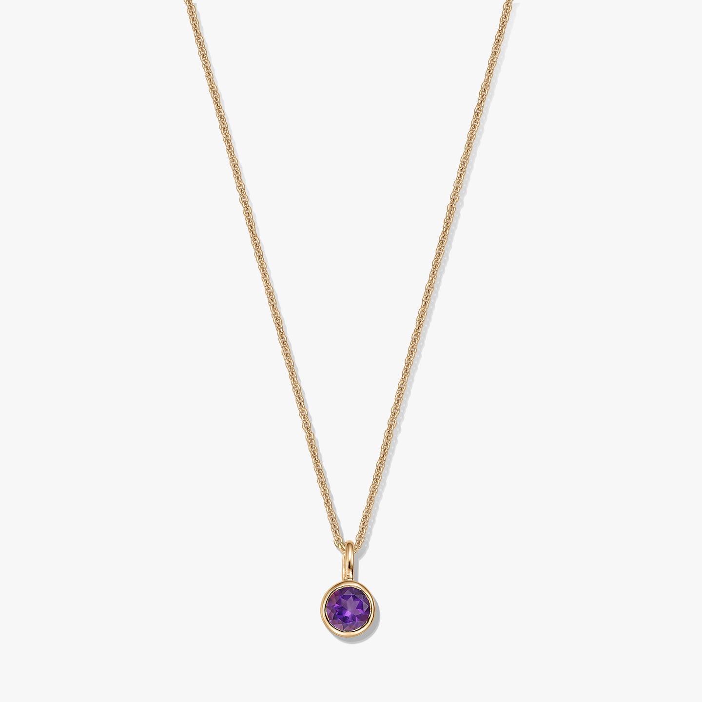 Collier en argent sterling plaqué or avec un petit pendentif rond en améthyste (pierre de naissance) sur fond blanc.